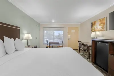 a hotel room with a large bed and a desk at Best Western Courtesy Hotel - Anaheim Resort Amusement Park in Anaheim