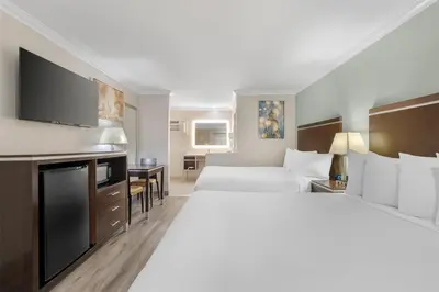 a hotel room with two beds and a flat screen tv at Best Western Courtesy Hotel - Anaheim Resort Amusement Park in Anaheim