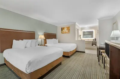 a hotel room with two beds and a bathroom at Best Western Courtesy Hotel - Anaheim Resort Amusement Park in Anaheim