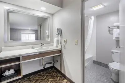 a bathroom with a sink and a toilet and a mirror at Best Western Airport Plaza Hotel – LAX Airport LA Stadium in Los Angeles