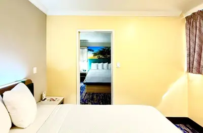 a hotel room with a bed and a mirror at Days Inn by Wyndham Los Angeles LAX Airport Stadium Area in Los Angeles
