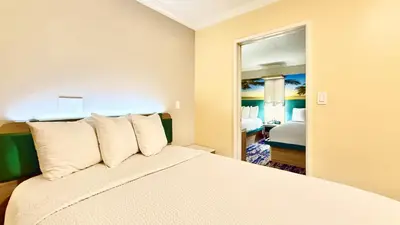 a hotel room with a bed and a mirror at Days Inn by Wyndham Los Angeles LAX Airport Stadium Area in Los Angeles