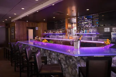a bar with purple lighting in a restaurant at E Central Hotel Downtown Los Angeles in Los Angeles