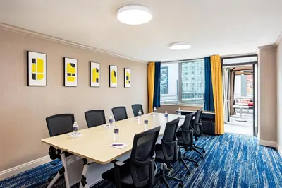 a conference room with a long table and chairs at E Central Hotel Downtown Los Angeles in Los Angeles