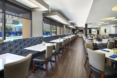 a dining room with tables and chairs at Holiday Inn Hotel & Suites Anaheim by IHG in Anaheim