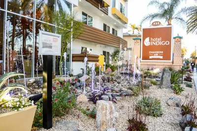 a garden in front of a hotel in front of a building at Hotel Indigo Anaheim by IHG in Anaheim