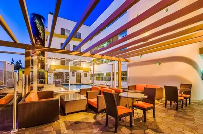 an outdoor patio with tables and chairs and a pool at Hotel Indigo Anaheim by IHG in Anaheim