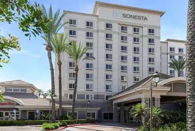 a hotel with palm trees in front of a building at Sonesta Anaheim Resort Area in Anaheim