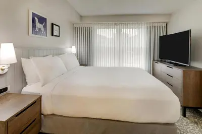 a bedroom with a large white bed and a flat screen tv at Sonesta ES Suites Anaheim Resort Area in Anaheim