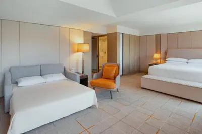 a hotel room with two beds and a chair at Sheraton Universal in Los Angeles