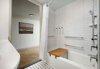 a white bathroom with a tub and a sink at Sonesta Los Angeles Airport LAX in Los Angeles