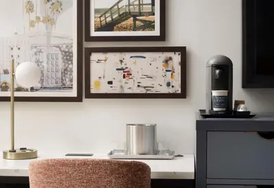 a desk with a chair and pictures on the wall at Sonesta Los Angeles Airport LAX in Los Angeles
