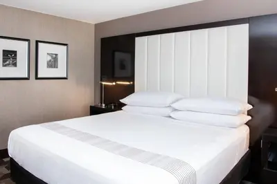 a bedroom with a large white bed with white pillows at Beverly Hills Marriott in Los Angeles