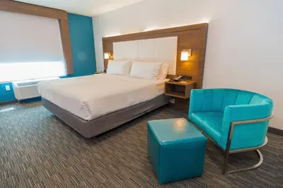 a hotel room with a bed and a blue chair at Holiday Inn Express Hollywood Walk of Fame by IHG in Los Angeles