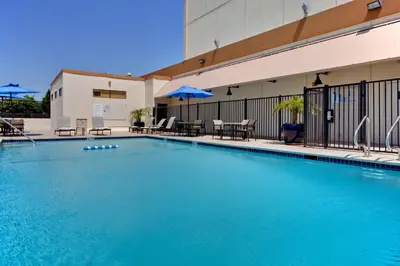 a large blue swimming pool in front of a building at Holiday Inn Los Angeles - LAX Airport by IHG in Los Angeles