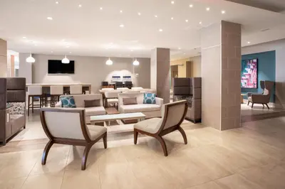 a living room with furniture and a dining room at Holiday Inn Los Angeles - LAX Airport by IHG in Los Angeles