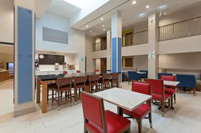 a cafeteria with tables and chairs and a bar at Holiday Inn Express West Los Angeles by IHG in Los Angeles