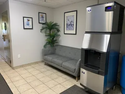 a living room with a couch and a fireplace at Hotel Marguerite South Anaheim - Garden Grove, Trademark Collection by Wyndham in Anaheim