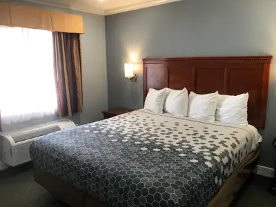 a hotel room with a bed and a window at Redondo Inn and Suites in Redondo Beach
