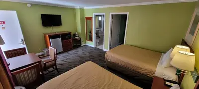 a hotel room with two beds and a television at Redondo Inn and Suites in Redondo Beach