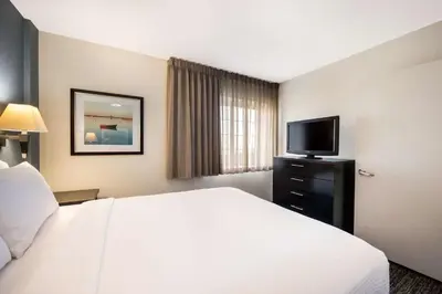 a hotel room with a bed and a flat screen tv at Sonesta Simply Suites Anaheim in Anaheim