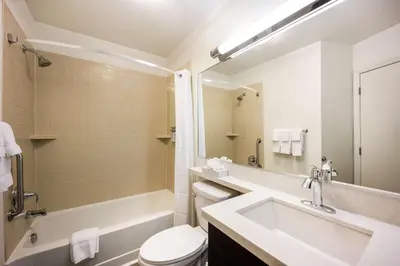 a bathroom with a sink and a tub and a toilet at Sonesta Simply Suites Anaheim in Anaheim