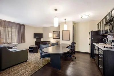 a living room with a table and chairs in a hotel room at Sonesta Simply Suites Anaheim in Anaheim