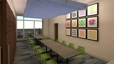 a cafeteria with wooden tables and green chairs at Holiday Inn Express Simi Valley by IHG in Simi Valley