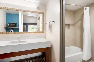 a bathroom with a sink and a tub and a mirror at Holiday Inn Express Simi Valley by IHG in Simi Valley