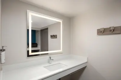 a white bathroom with a sink and a mirror at Holiday Inn Express Hotel & Suites Ventura Harbor by IHG in Ventura
