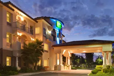 a hotel with a sign on the side of it at Holiday Inn Express & Suites Corona by IHG in Corona