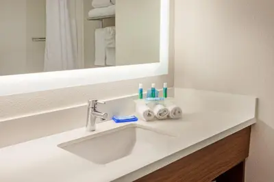 a bathroom with a sink and a mirror at Holiday Inn Express & Suites Corona by IHG in Corona