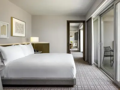 a hotel room with a bed and a corridor at Fairmont Century Plaza Los Angeles at Beverly Hills in Los Angeles