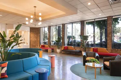 a lobby with couches and tables and windows at Hotel Burbank in Burbank
