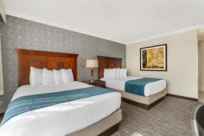 a hotel room with two beds and a desk at Best Western Plus Carriage Inn in Sherman Oaks