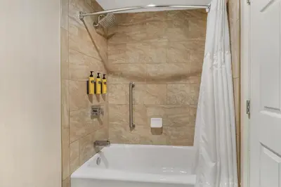 a bathroom with a tub and a shower with a shower curtain at Best Western Plus Carriage Inn in Sherman Oaks