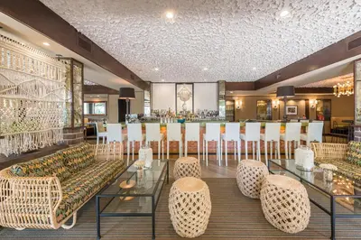 a restaurant with a bar with chairs and tables at The Garland in Los Angeles