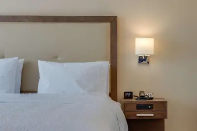 a bedroom with a bed and a night stand with a lamp at Hampton Inn & Suites Los Angeles - Glendale in Glendale