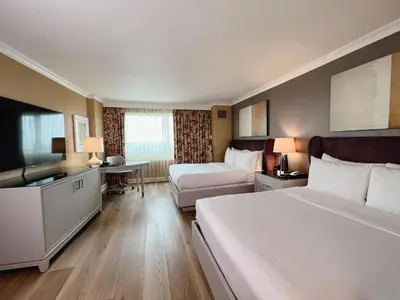 a hotel room with two beds and a flat screen tv at The Commerce Casino & Hotel in Commerce
