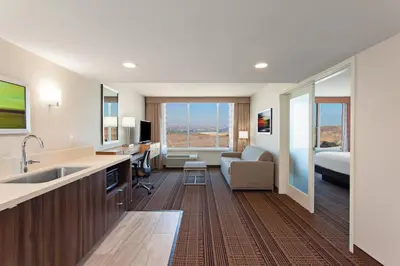a hotel room with a kitchen and a bedroom at Holiday Inn Diamond Bar - Pomona by IHG in Diamond Bar