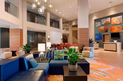 a lobby of a hotel with blue couches and tables at Delta Hotels by Marriott Anaheim Garden Grove in Anaheim