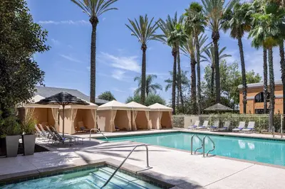 a swimming pool with palm trees in the background at Delta Hotels by Marriott Anaheim Garden Grove in Anaheim
