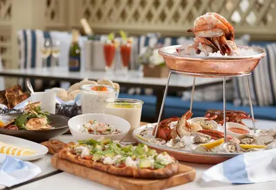 a table with a tray of food with shrimp and other foods at The Peninsula Beverly Hills in Los Angeles