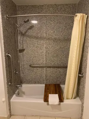 a bath tub with a shower with a shower curtain at El Segundo Inn in Hawthorne