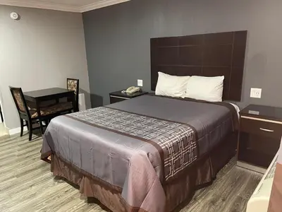 a hotel room with a large bed and a desk at El Segundo Inn in Hawthorne