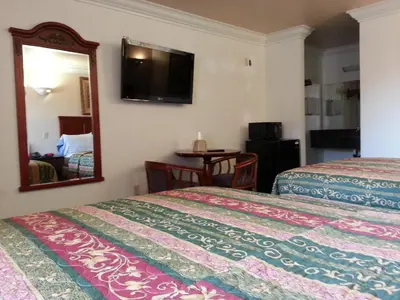 a hotel room with two beds and a mirror at Royal Inn Motel Long Beach in Long Beach