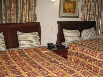 a hotel room with two beds and a phone on a table at Royal Inn Motel Long Beach in Long Beach