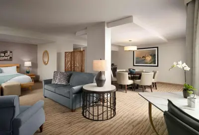 a hotel room with a bed and a living room at Sonesta Redondo Beach and Marina in Redondo Beach