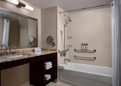 a bathroom with a tub and a sink and a shower at Sonesta Redondo Beach and Marina in Redondo Beach