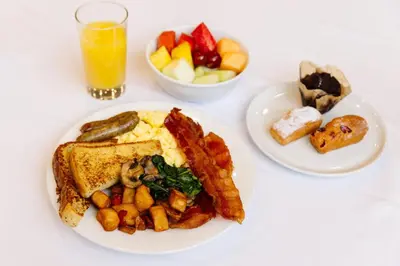 a white table with a plate of breakfast foods and a glass of orange juice at Holiday Inn Los Angeles Gateway-Torrance by IHG in Torrance